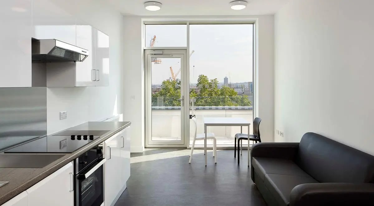 Modern kitchen with living area and sofa kitchen living room at Townhall Camberwell in London Student Accommodation