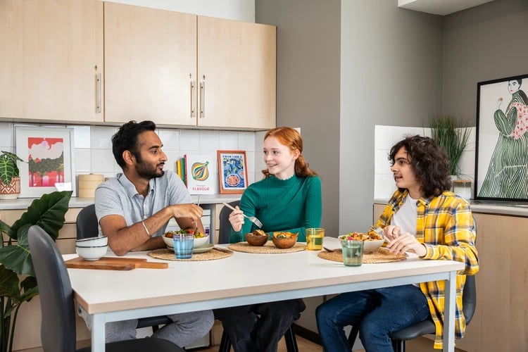 Students eating at a table kitchen area at Ewen Henderson Court in London Student Accommodation