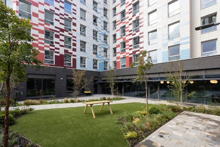 Courtyard with picnic table and modern building exterior at Arch View House in London Student Accommodation