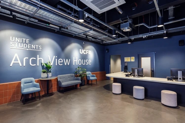 Reception desk with chairs and plants lobby area at Arch View House in London Student Accommodation