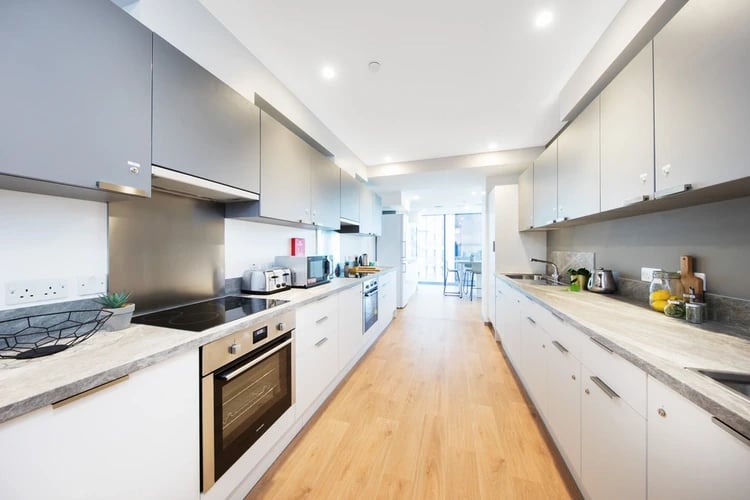 Modern kitchen with white cabinets oven and toaster kitchen at Arch View House in London Student Accommodation