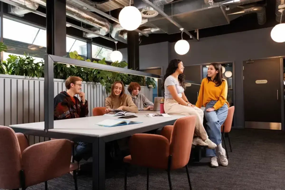 Students at a table studying and chatting living room at Arch View House in London Student Accommodation