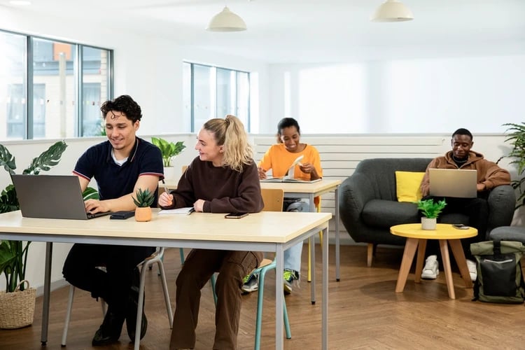 Students using laptops at desks and couch communal area at Blithehale Court in London Student Accommodation