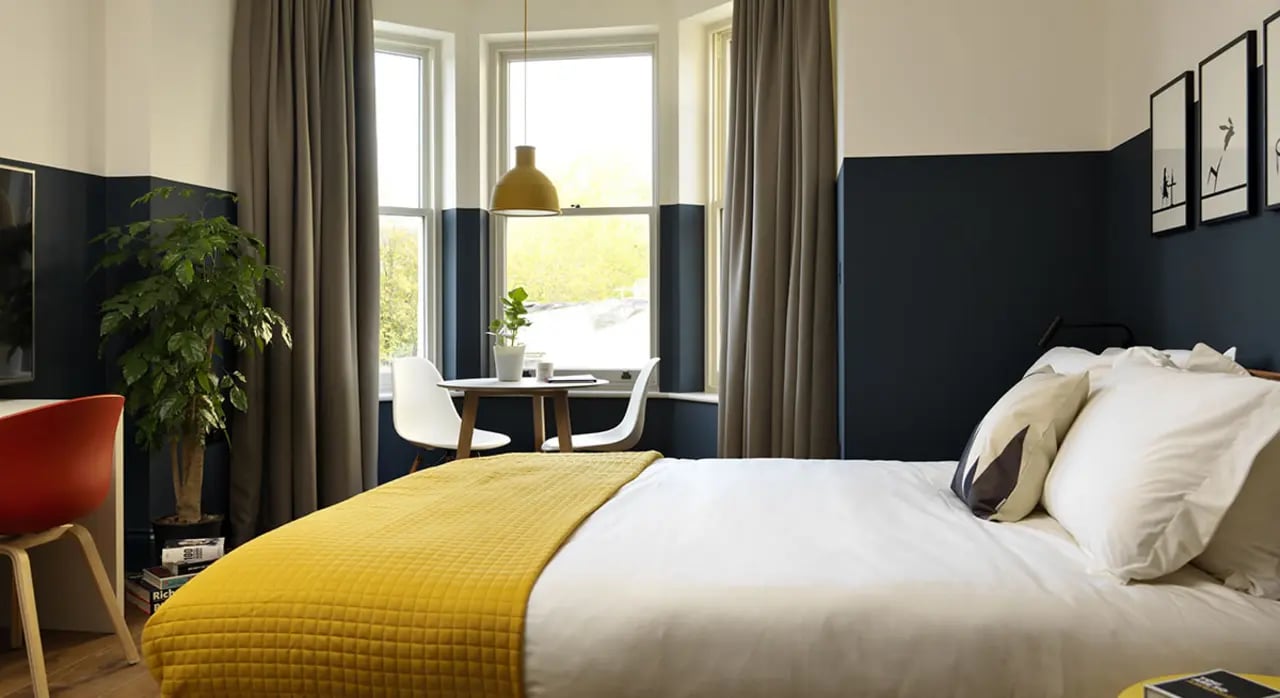 Bed with yellow blanket desk plant dining table Bedroom at Student Castle Bath in Bath Student Accommodation