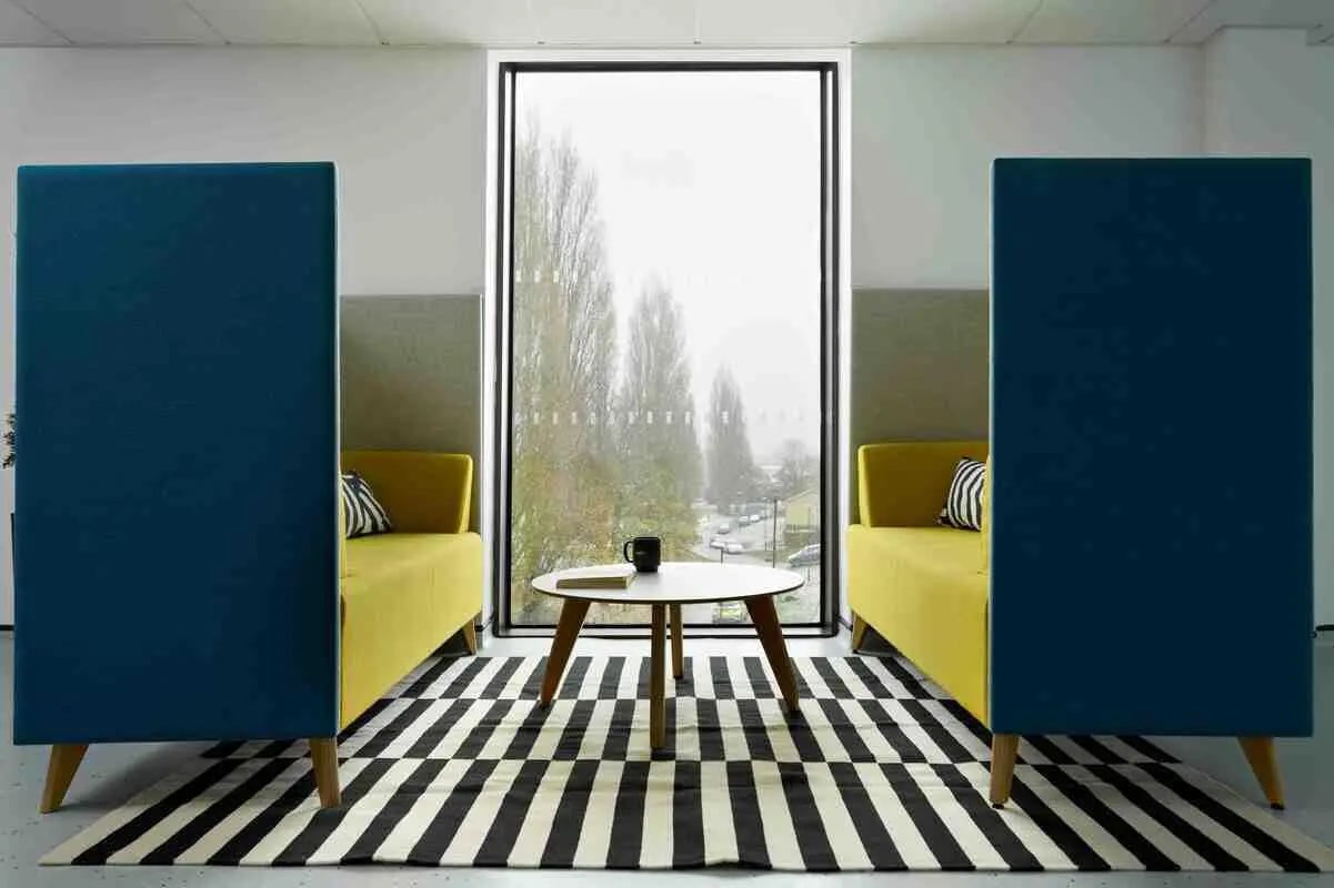 Yellow sofas coffee table privacy booths living room at Westwood Student Mews in Coventry Student Accommodation
