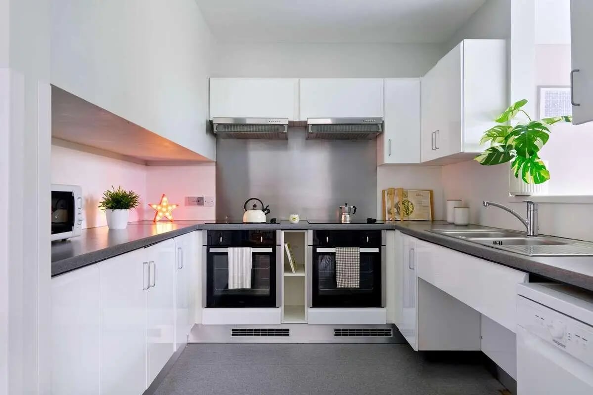 Modern white kitchen with ovens sink and microwave kitchen at Westwood Student Mews in Coventry Student Accommodation