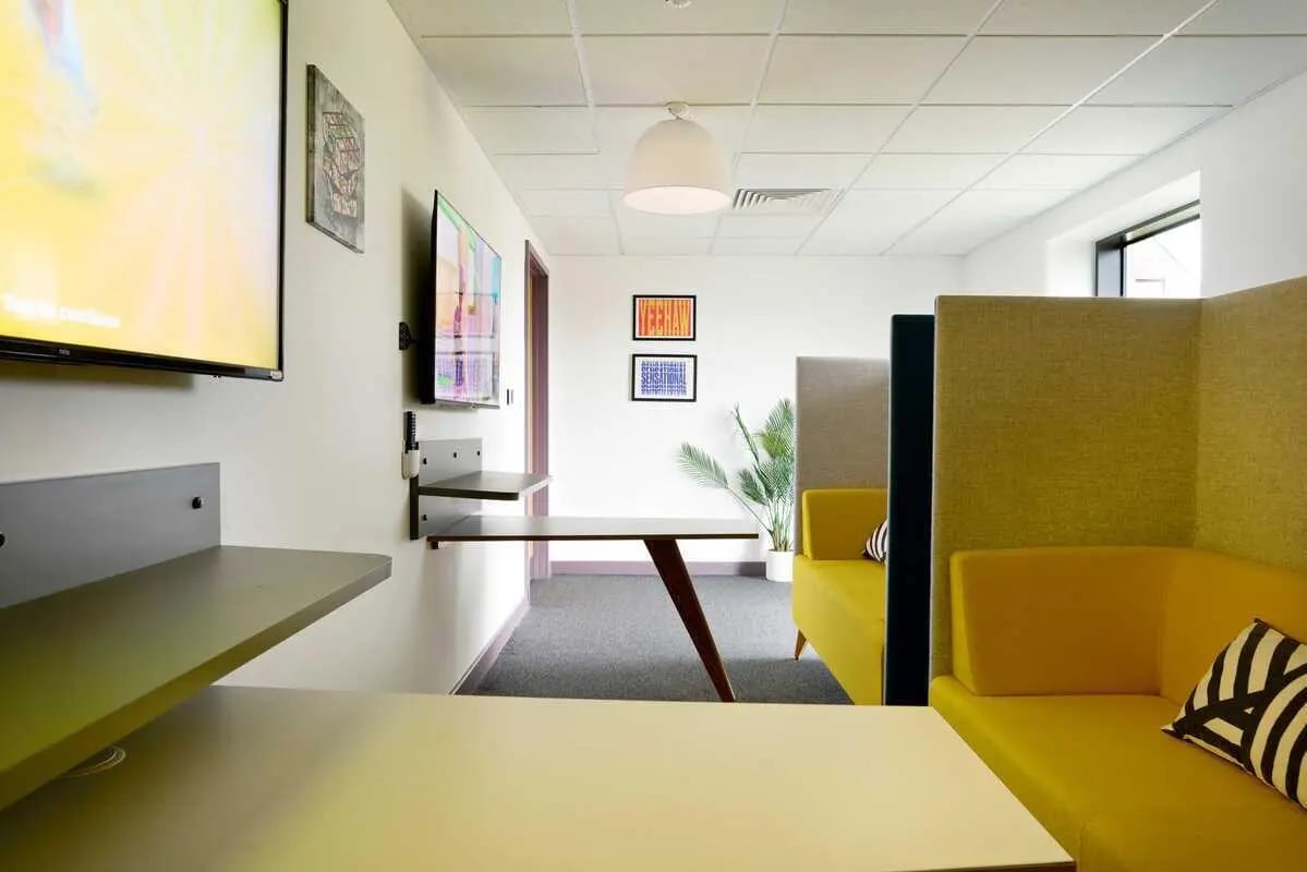 Yellow couches two TVs and desk living room at Westwood Student Mews in Coventry Student Accommodation