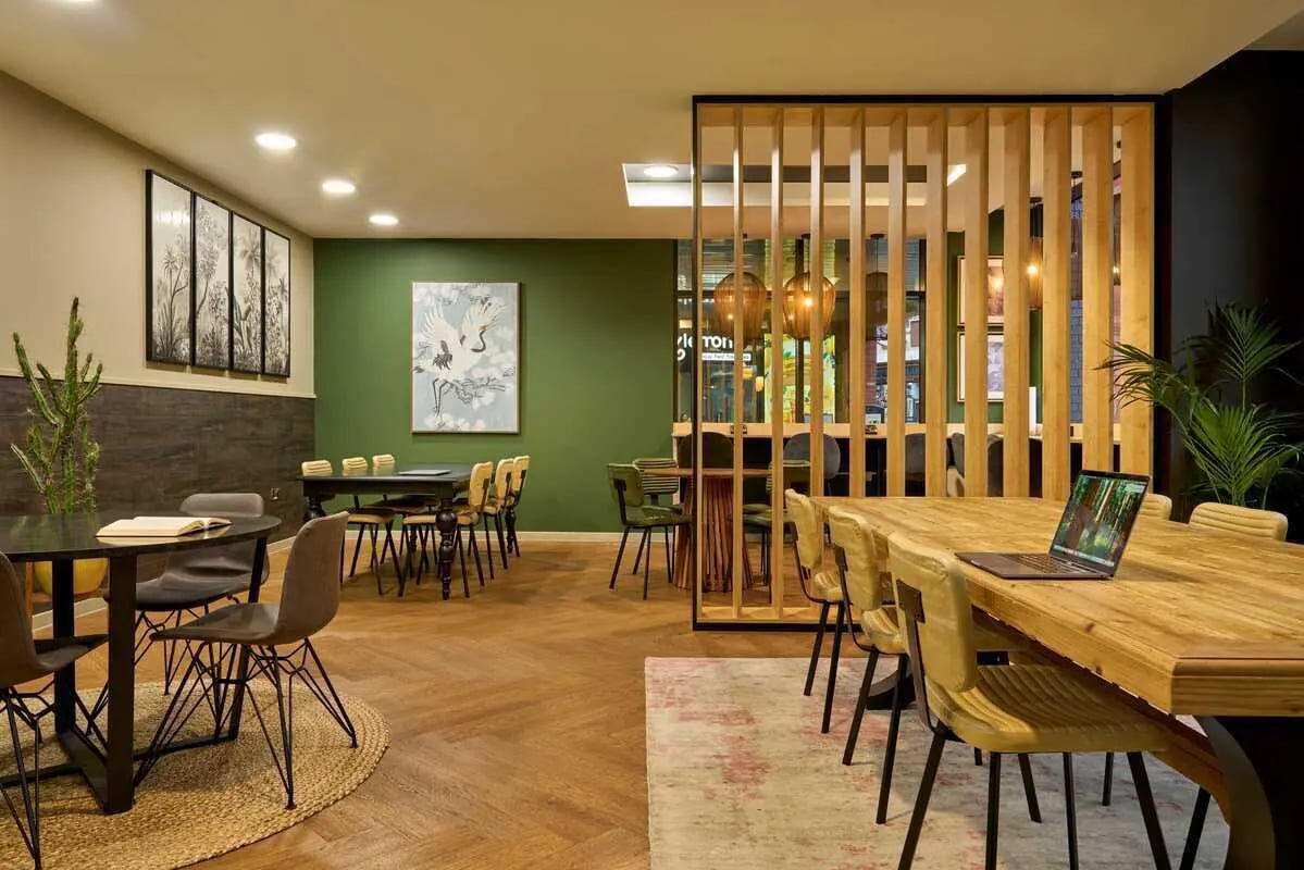 Dining tables chairs laptop and art communal area at Millennium View in Coventry Student Accommodation