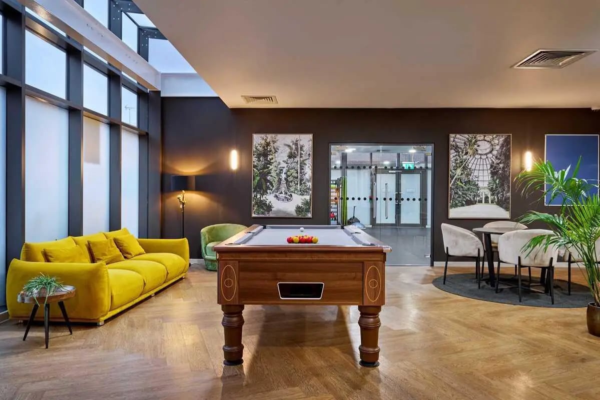 Pool table sofa chairs and plants common room at Millennium View in Coventry Student Accommodation
