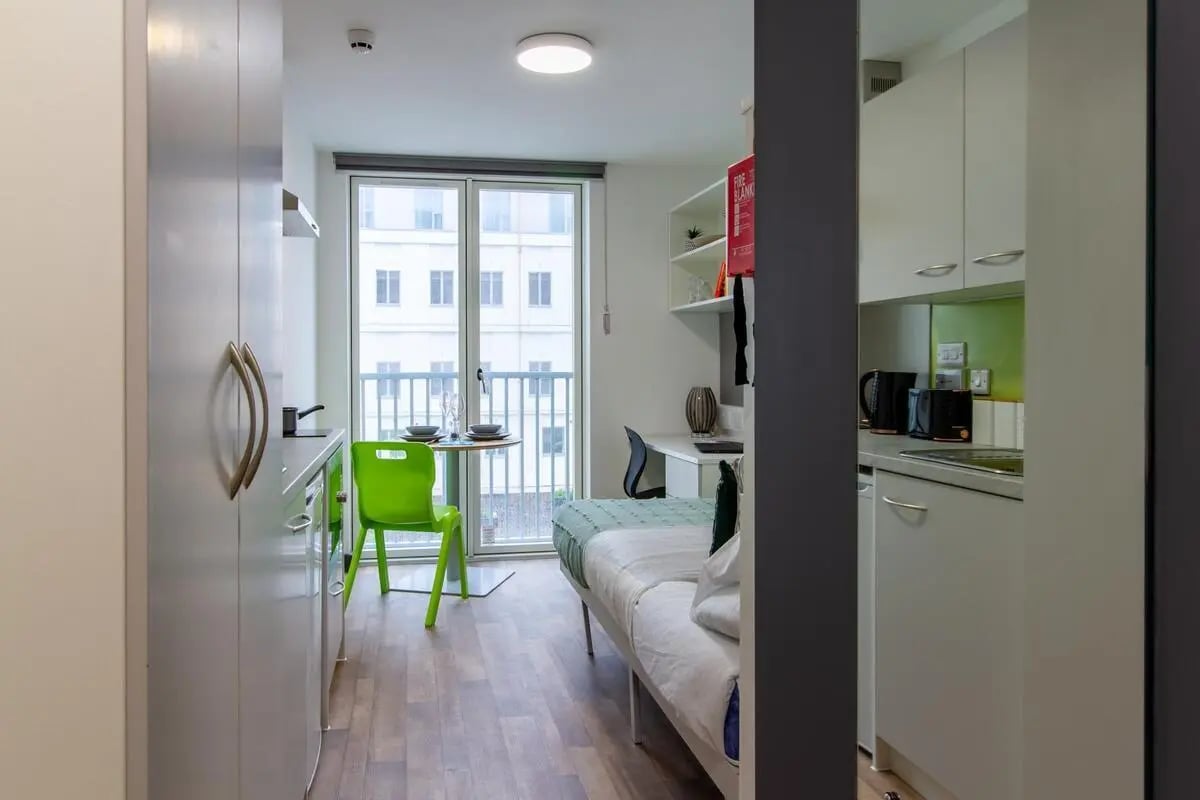 Bed kitchen desk table and chairs studio apartment at Plymouth Cross House in Plymouth Student Accommodation