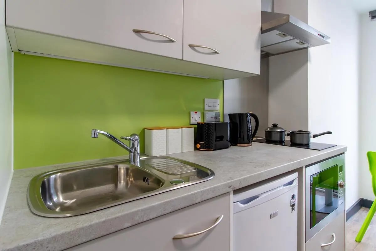 Sink kettle toaster microwave kitchen area at Plymouth Cross House in Plymouth Student Accommodation