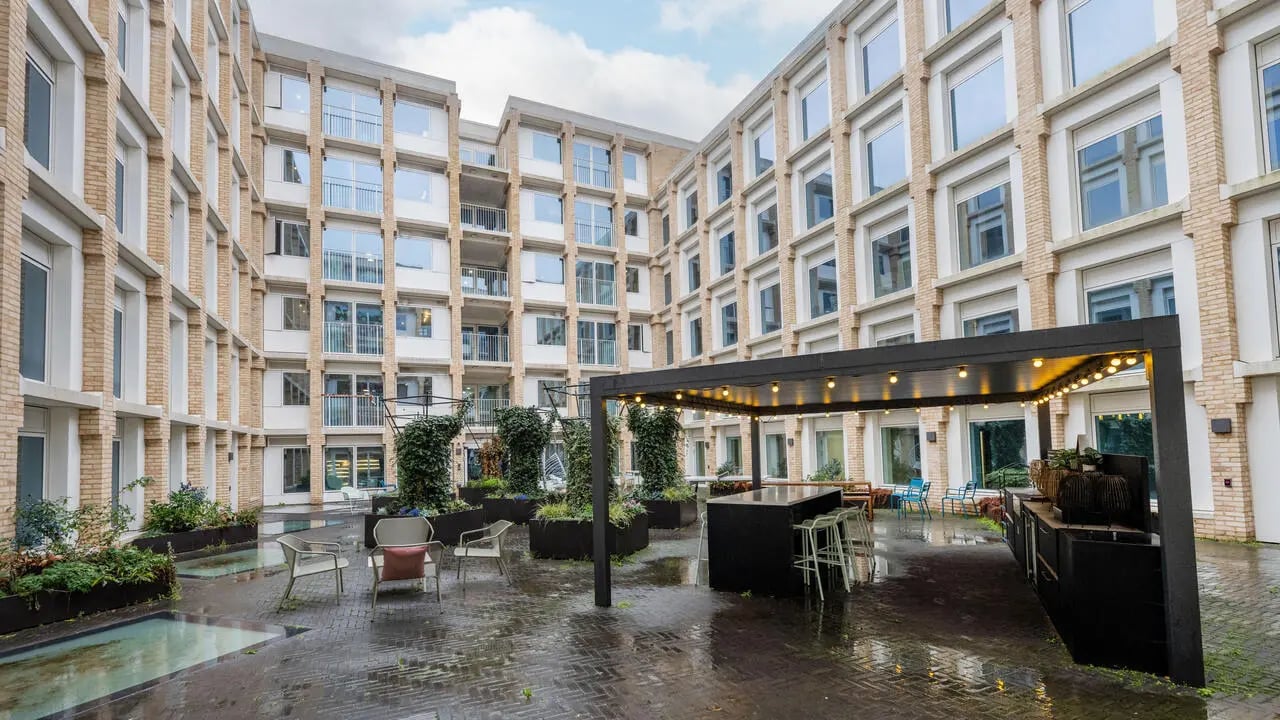 Courtyard seating bar area with planters exterior at Wick Park in London Student Accommodation