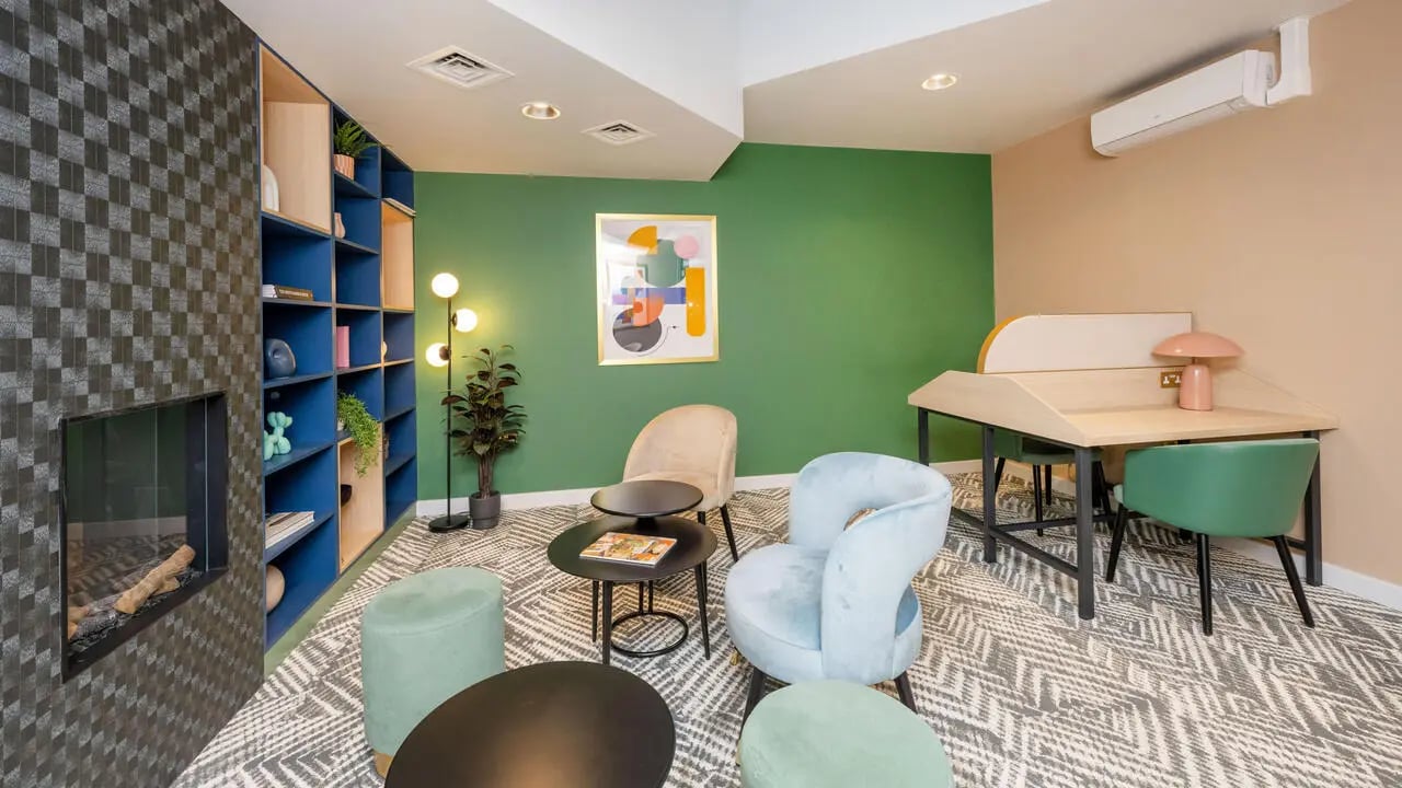 Stylish lounge with fireplace chairs and desks communal area at Wick Park in London Student Accommodation