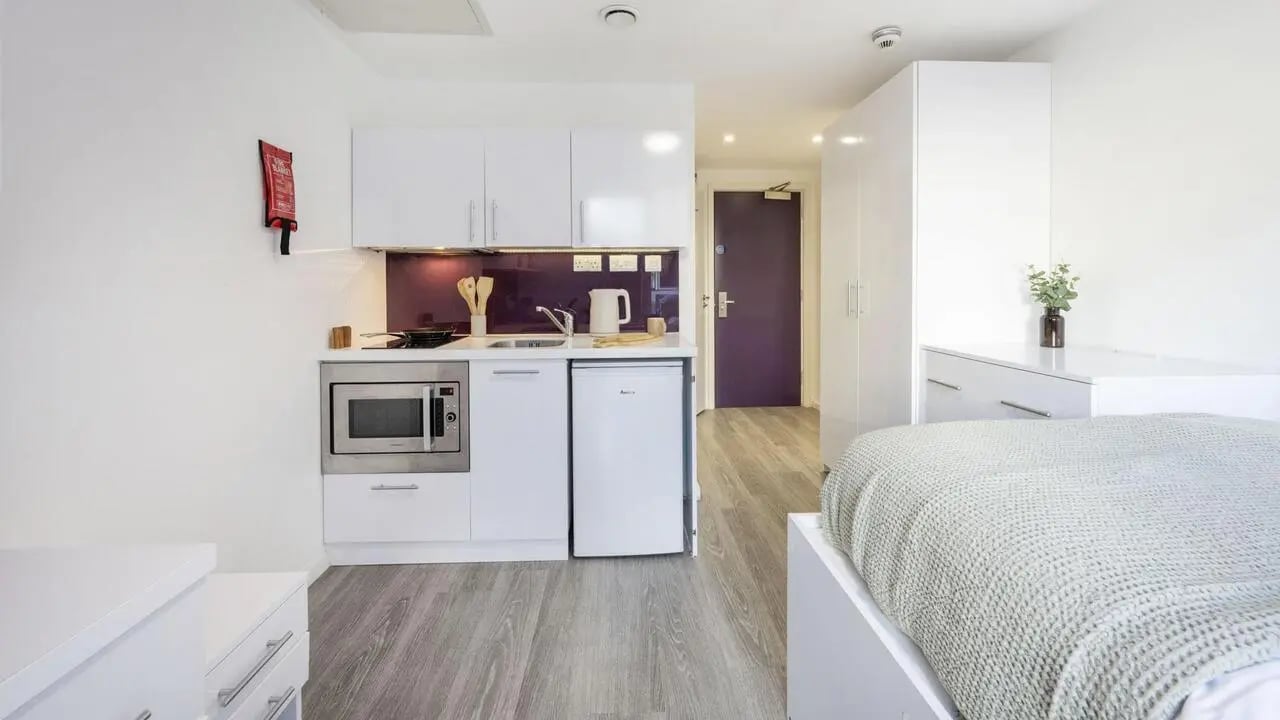 Kitchen microwave sink fridge stove bed living room at The Cube Ealing in London Student Accommodation