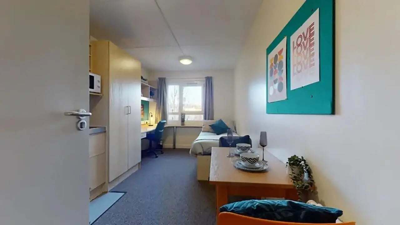 Desk bed cabinets and microwave student studio bedroom at Creek Court in London Student Accommodation