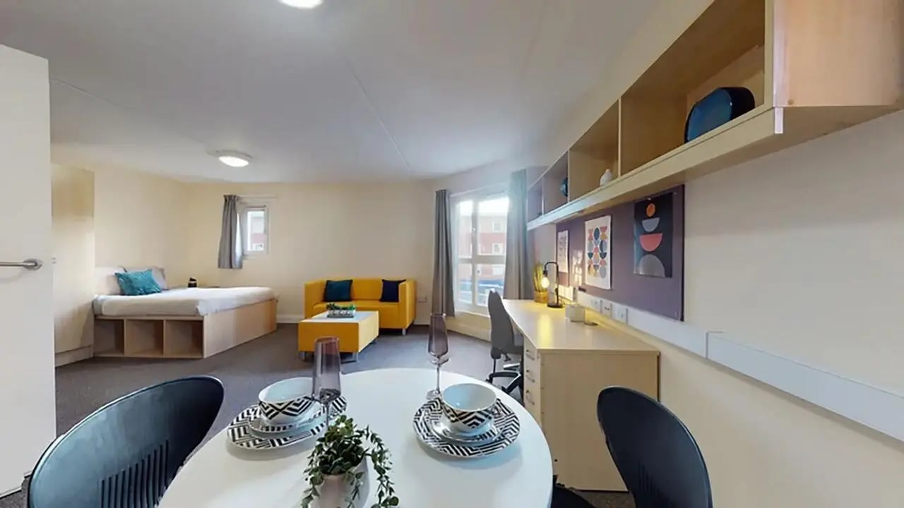 Bed sofa desk and dining table living room at Creek Court in London Student Accommodation