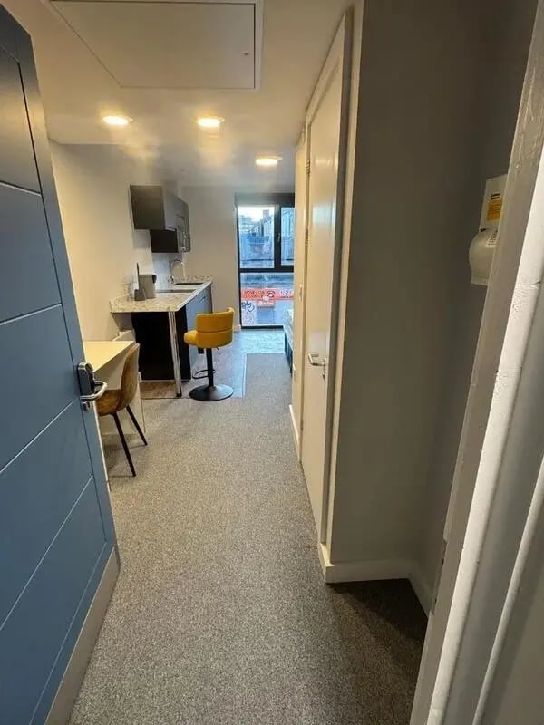 Kitchenette with yellow stool and table study area at Cleveland Apartments in Wolverhampton Student Accommodation