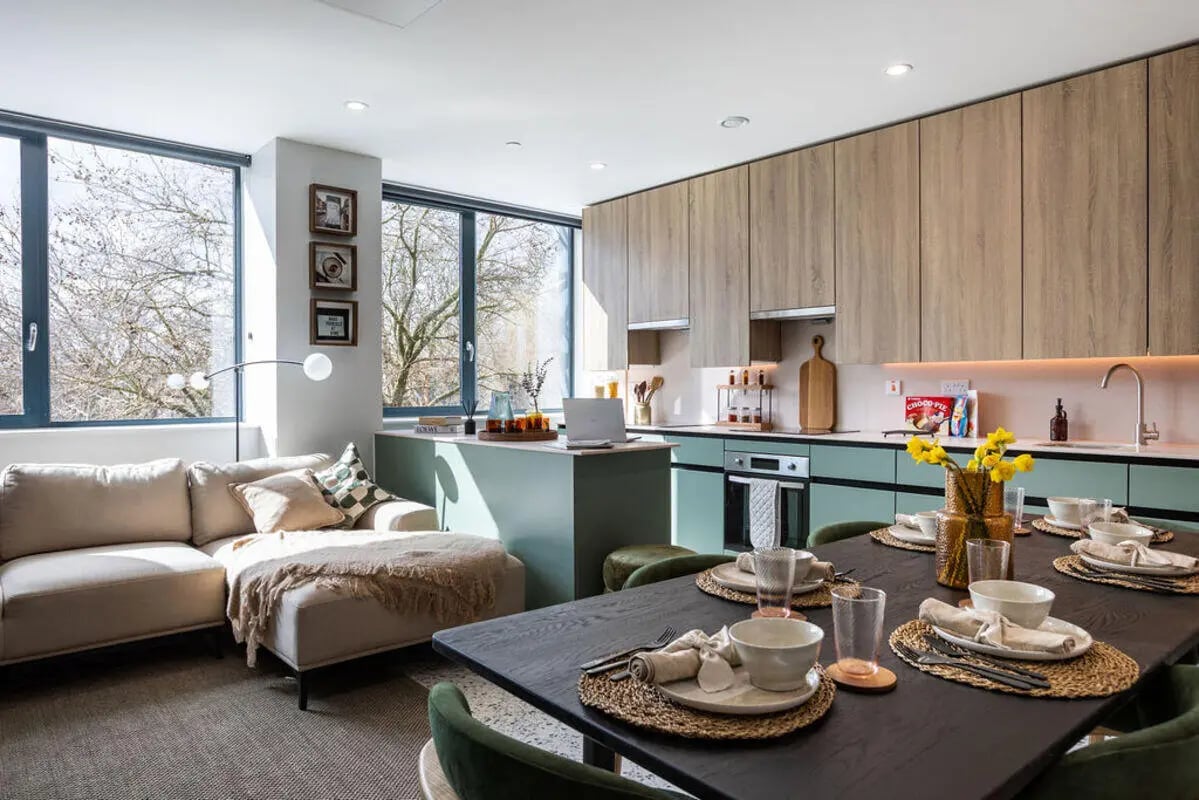 Sofa island kitchen dining table with place settings living area at Yugo Haüs in Birmingham Student Accommodation