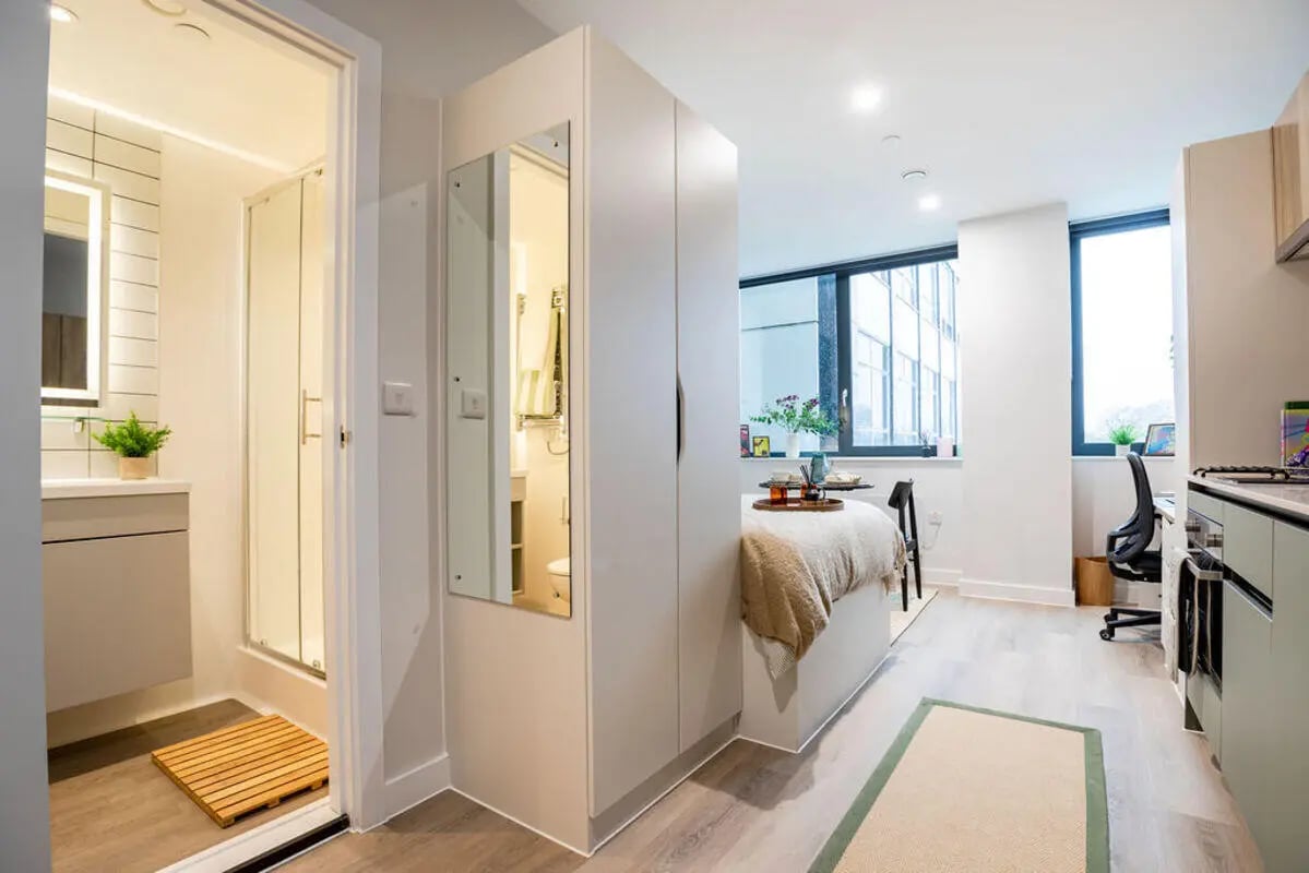 Bed desk and bathroom of studio apartment at Yugo Haüs in Birmingham Student Accommodation