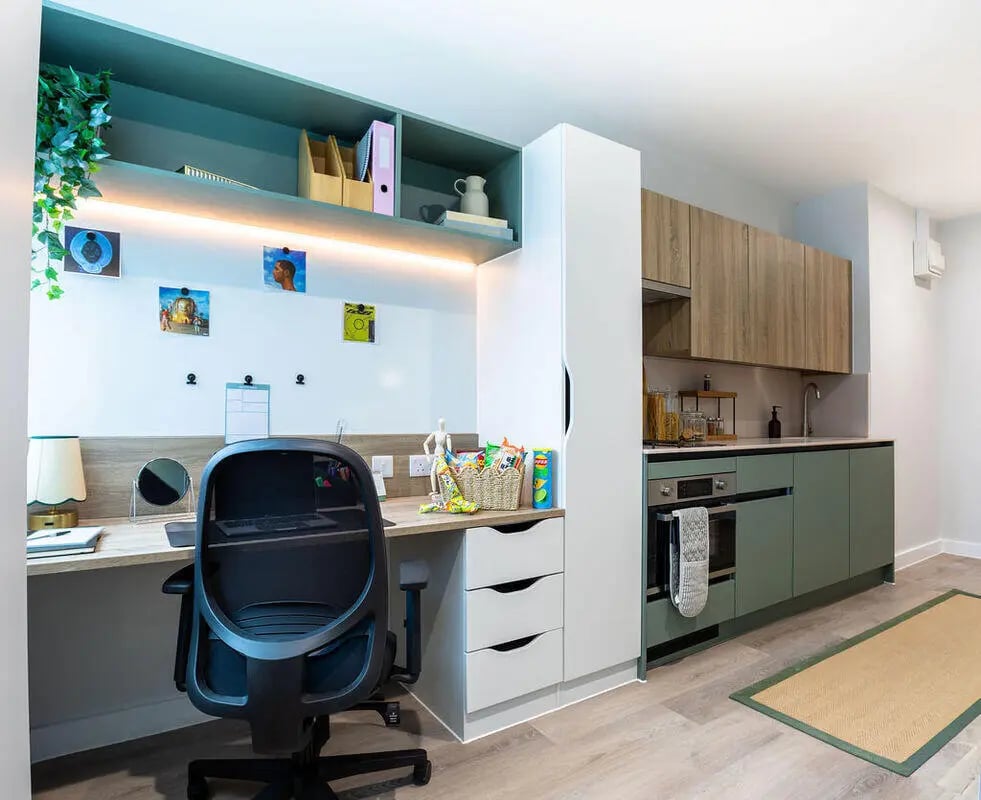 Desk chair kitchen appliances and cabinets living room at Yugo Haüs in Birmingham Student Accommodation