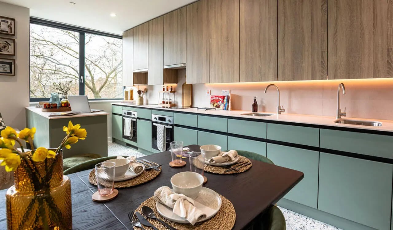 Table setting with flowers and modern kitchen at Yugo Haüs in Birmingham Student Accommodation