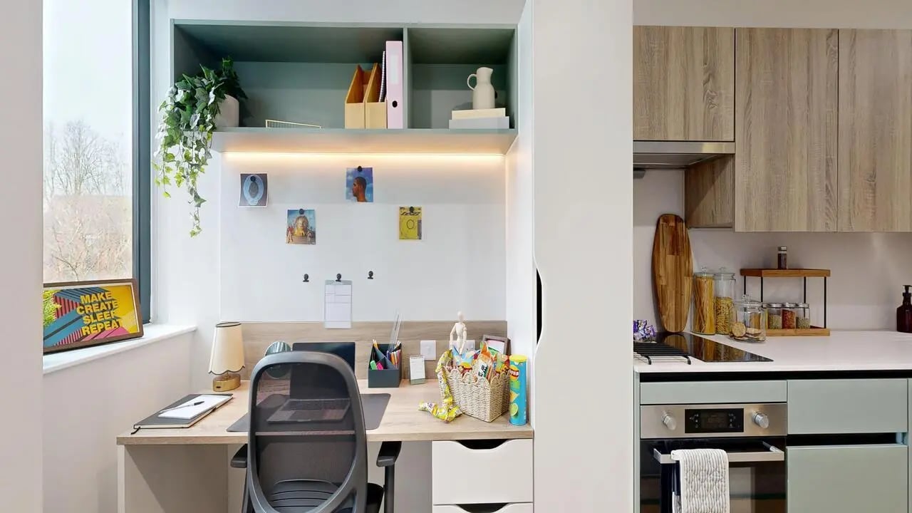Desk chair laptop plant and kitchen counter Study kitchen at Yugo Haüs in Birmingham Student Accommodation