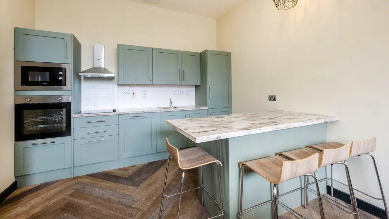 Kitchen with grey cabinets island and stools kitchen at Fontenoy Apartments in Liverpool Student Accommodation