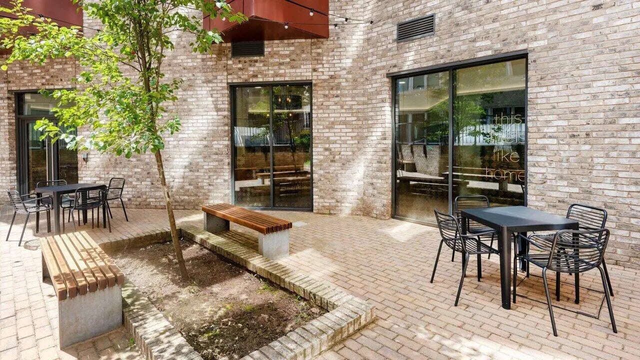 Tables chairs benches with tree courtyard exterior at Fontenoy Apartments in Liverpool Student Accommodation