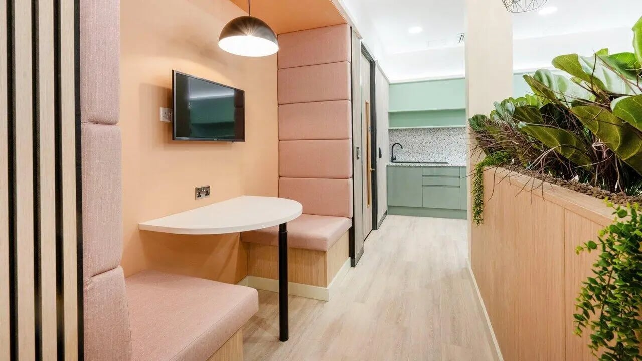 Pink seating booth with TV and kitchen area at Fontenoy Apartments in Liverpool Student Accommodation