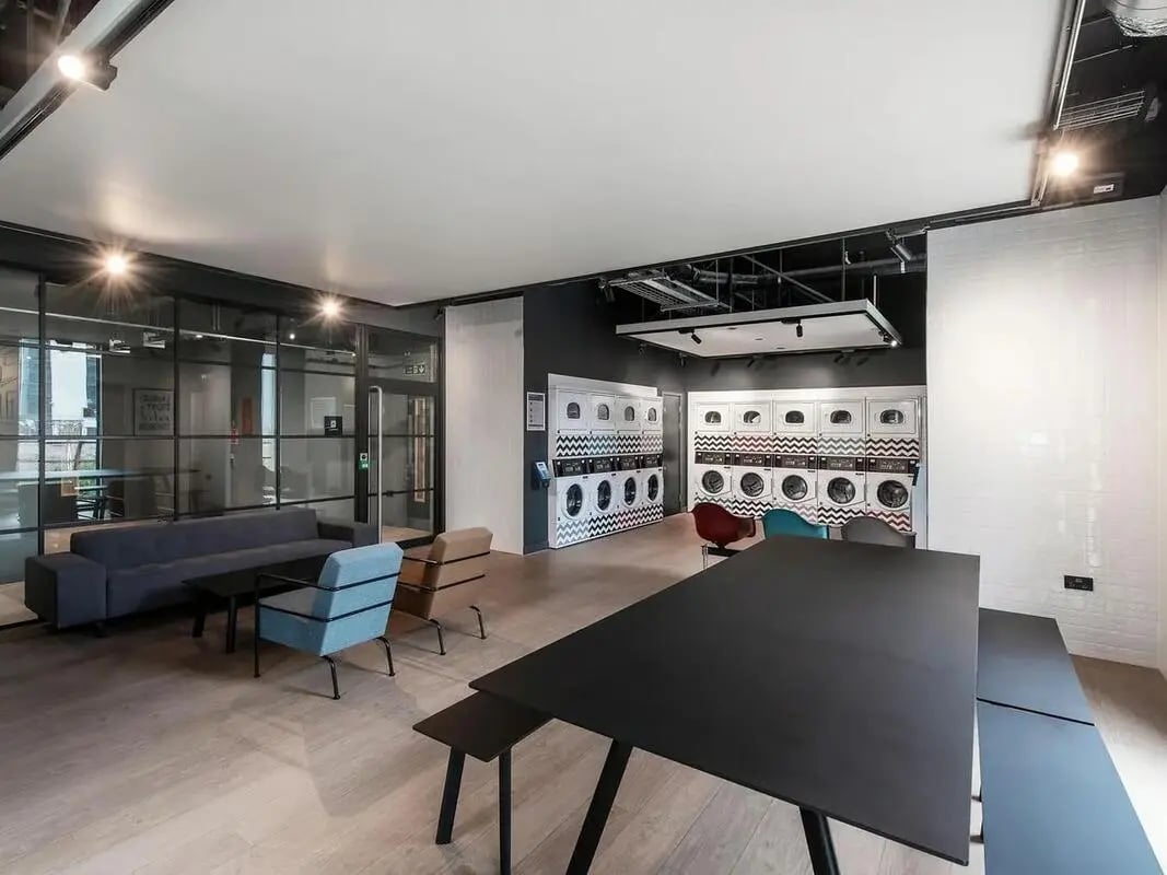 Sofa tables chairs and washing machines common area at Zenith in Cardiff Student Accommodation