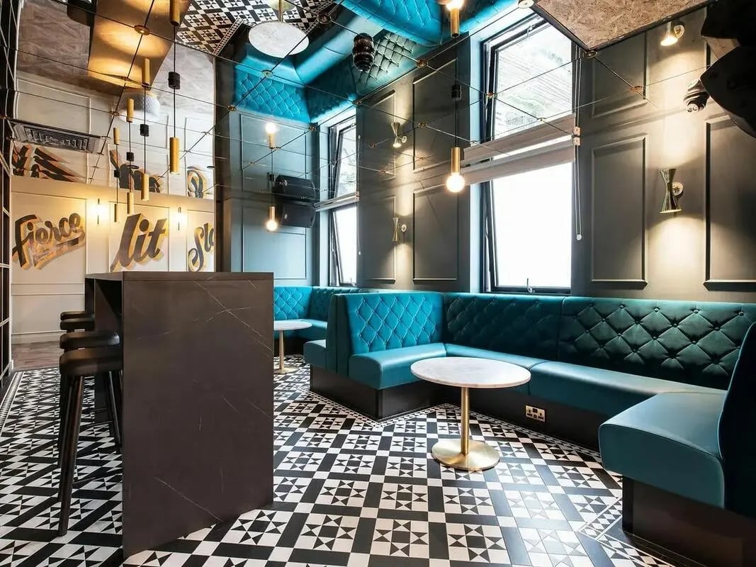 Turquoise booth seating marble tables bar stools lounge area at Zenith in Cardiff Student Accommodation