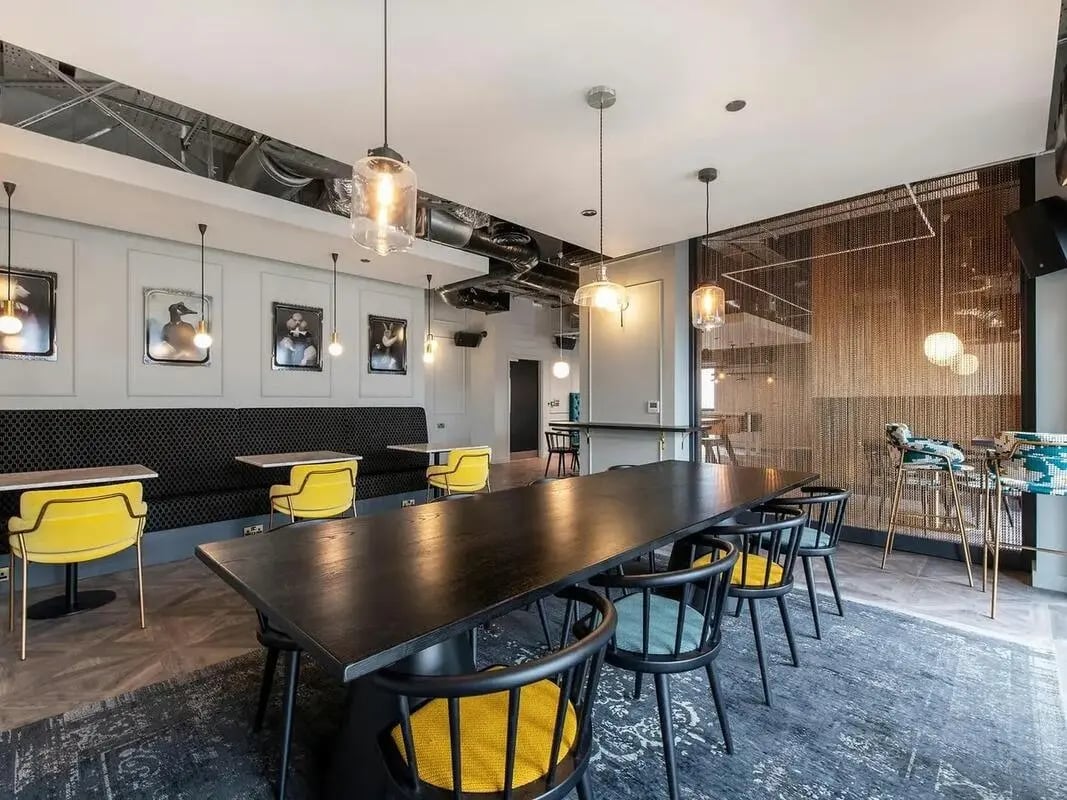 Long table yellow chairs art dining area at Zenith in Cardiff Student Accommodation