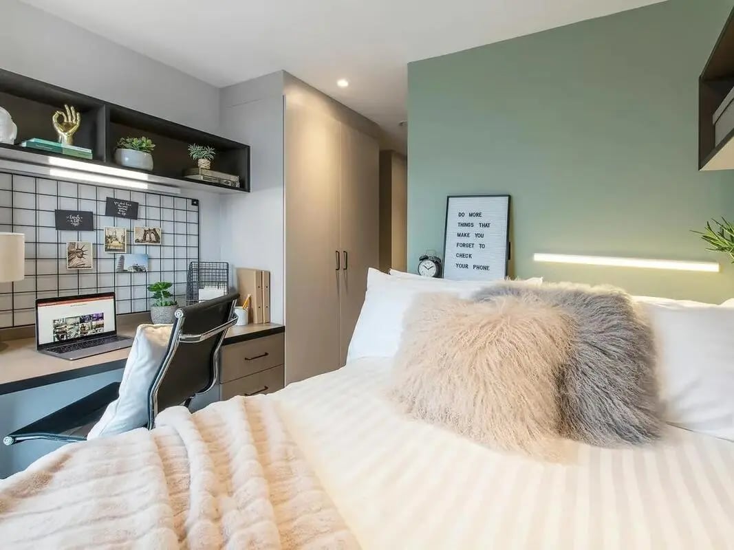 Desk with laptop and bed with pillows Bedroom at Zenith in Cardiff Student Accommodation