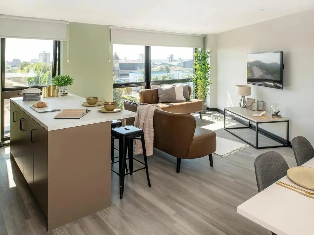 Kitchen island seating area with living room living room at Zenith in Cardiff Student Accommodation