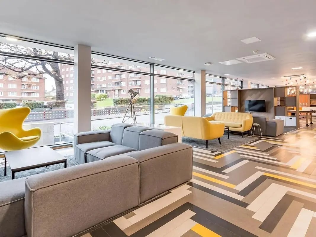 Modern lounge with grey sofas yellow chairs living room at ViBe Student Living in Kingston Upon Thames Student Accommodation