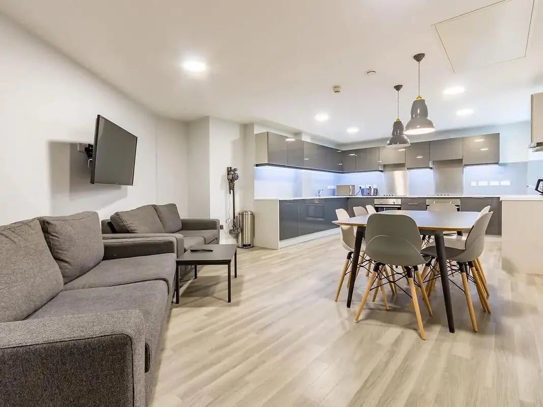 Two sofas dining table chairs kitchen living room at ViBe Student Living in Kingston Upon Thames Student Accommodation