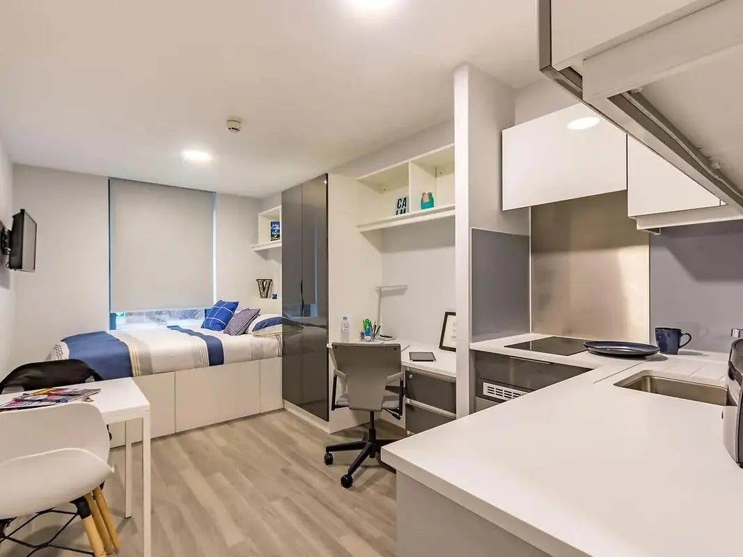 Bed desk wardrobe and kitchen area studio at ViBe Student Living in Kingston Upon Thames Student Accommodation