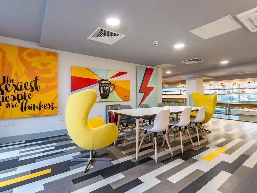 Yellow chairs artwork table chairs communal area at ViBe Student Living in Kingston Upon Thames Student Accommodation