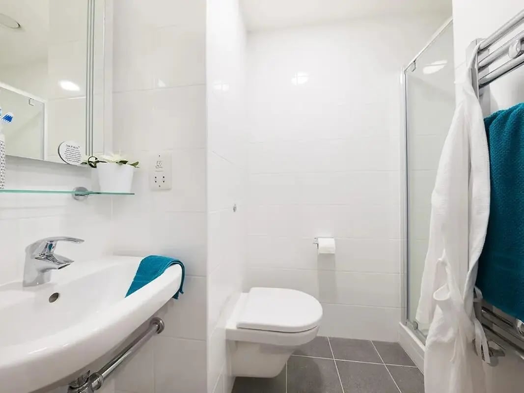 Sink toilet shower robe towels Bathroom at Felda House in Wembley Student Accommodation