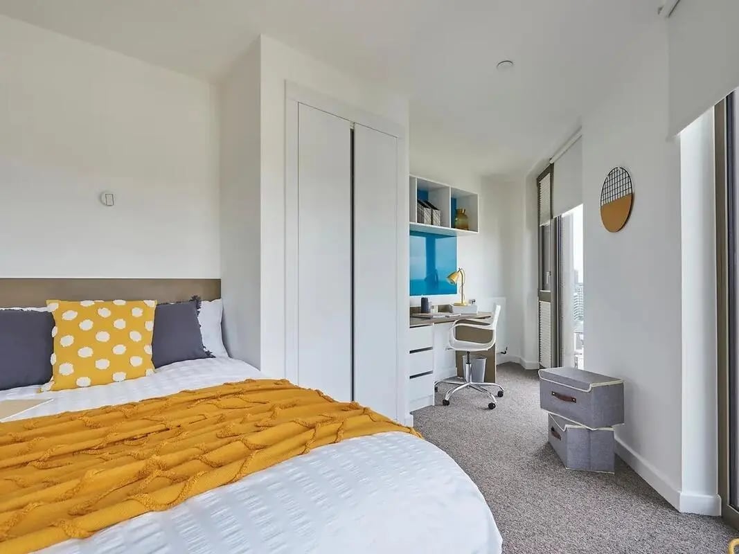 Bed white yellow blue desk chair bedroom at Felda House in Wembley Student Accommodation