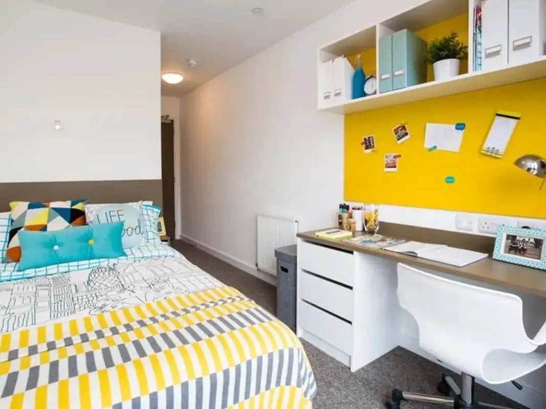 Bed desk chair shelves and yellow board Bedroom at Felda House in Wembley Student Accommodation