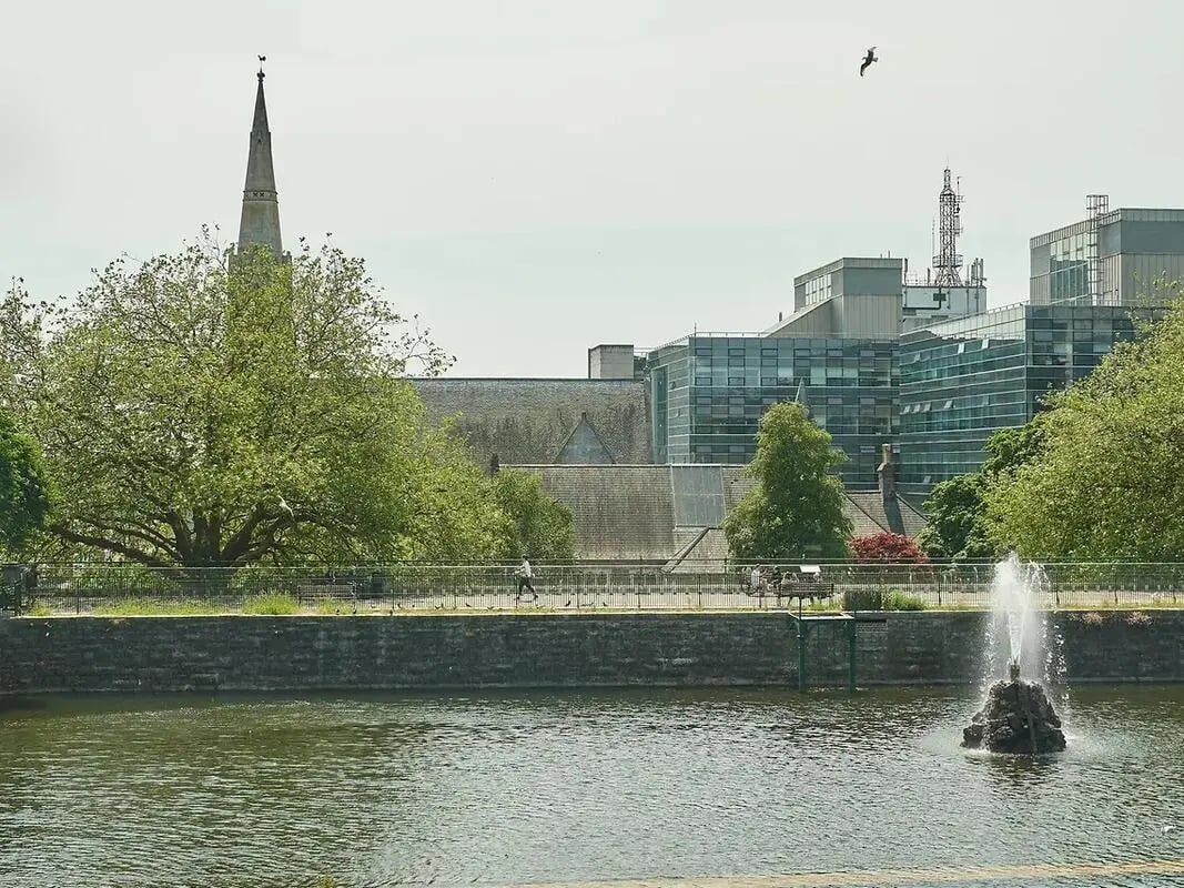 Waterfront view with modern buildings and fountain exterior at The Reservoir in Plymouth Student Accommodation