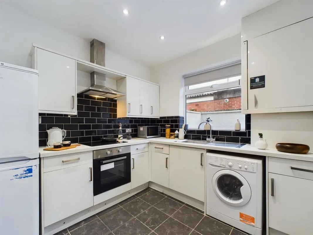 White kitchen appliances with black tiled backsplash kitchen at 4 Bedroom House at 102, Leopold Road in Liverpool Student Accommodation