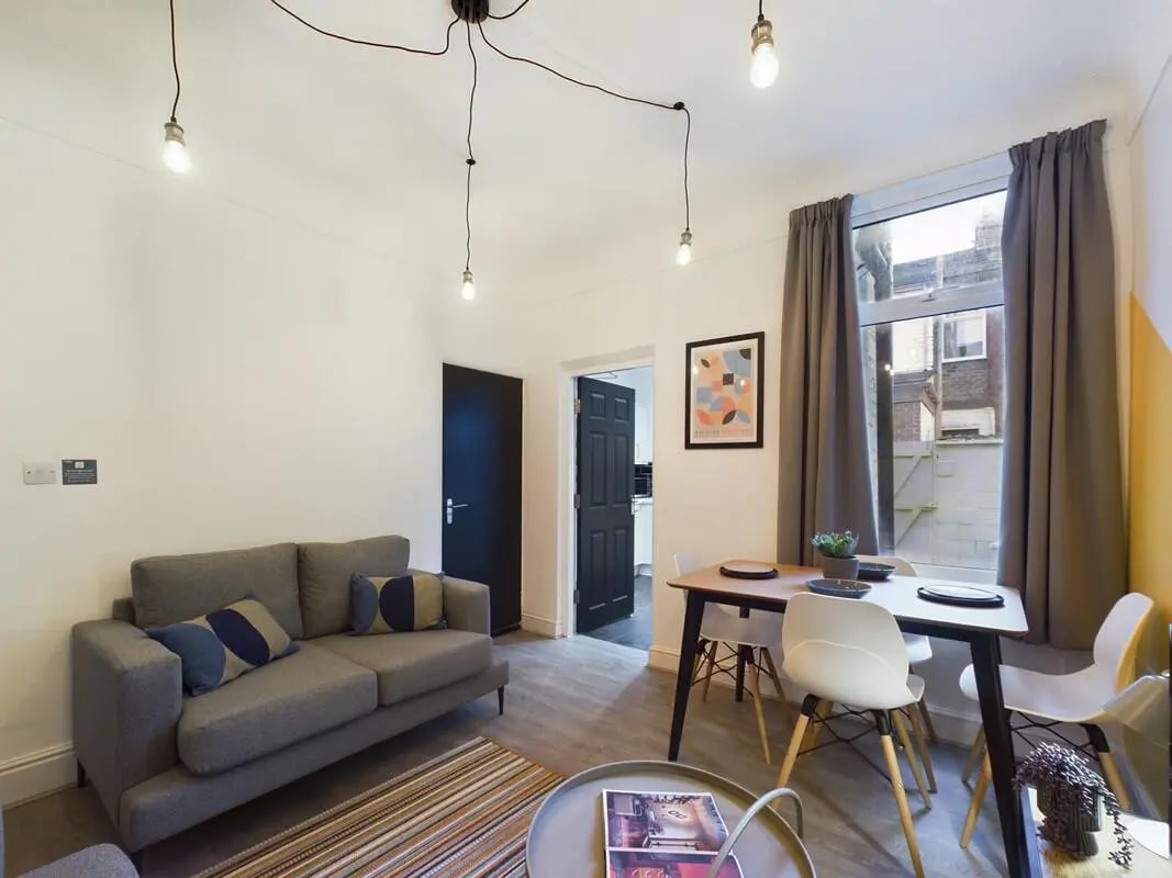 Sofa dining table artwork and lights living room at 4 Bedroom House at 102, Leopold Road in Liverpool Student Accommodation