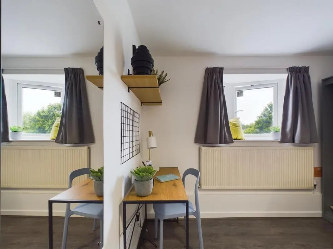 Two desks plants lamps windows and curtains study area at 6 Bedroom House at 2, Flat 2, Windsor House, Clint Road West in Liverpool Student Accommodation