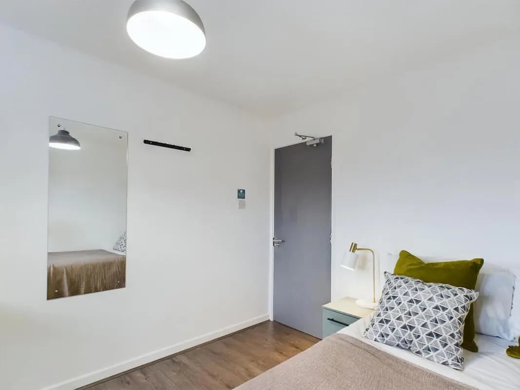 Bed bedside lamp pillows and mirror bedroom at 6 Bedroom House at 2, Flat 2, Windsor House, Clint Road West in Liverpool Student Accommodation