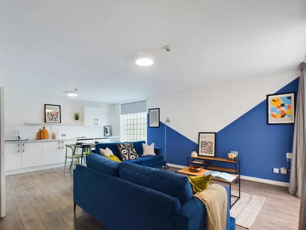 Blue sofas modern kitchen artworks living room at 6 Bedroom House at 2, Flat 2, Windsor House, Clint Road West in Liverpool Student Accommodation