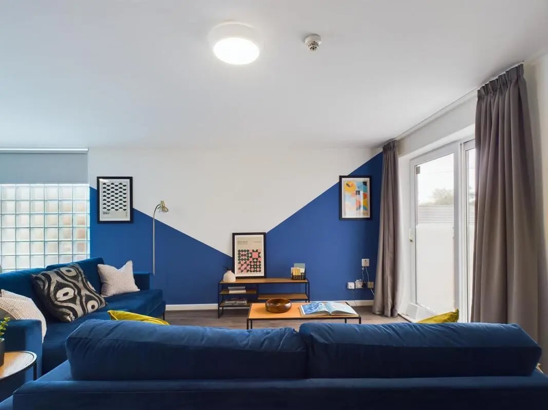 Blue sofas coffee table artwork living room at 6 Bedroom House at 2, Flat 2, Windsor House, Clint Road West in Liverpool Student Accommodation