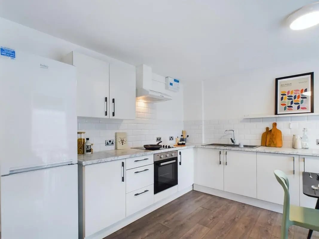 White cabinets fridge oven sink artwork kitchen at 6 Bedroom House at 2, Flat 2, Windsor House, Clint Road West in Liverpool Student Accommodation