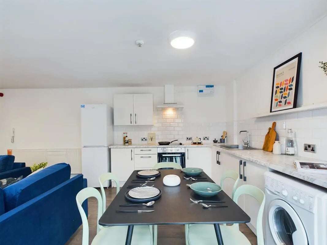 Dining table with place settings and kitchen appliances kitchen at 6 Bedroom House at 2, Flat 2, Windsor House, Clint Road West in Liverpool Student Accommodation